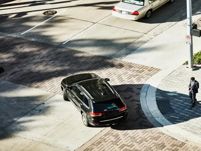 Aerial view of a black luxury SUV pulling out of a driveway.